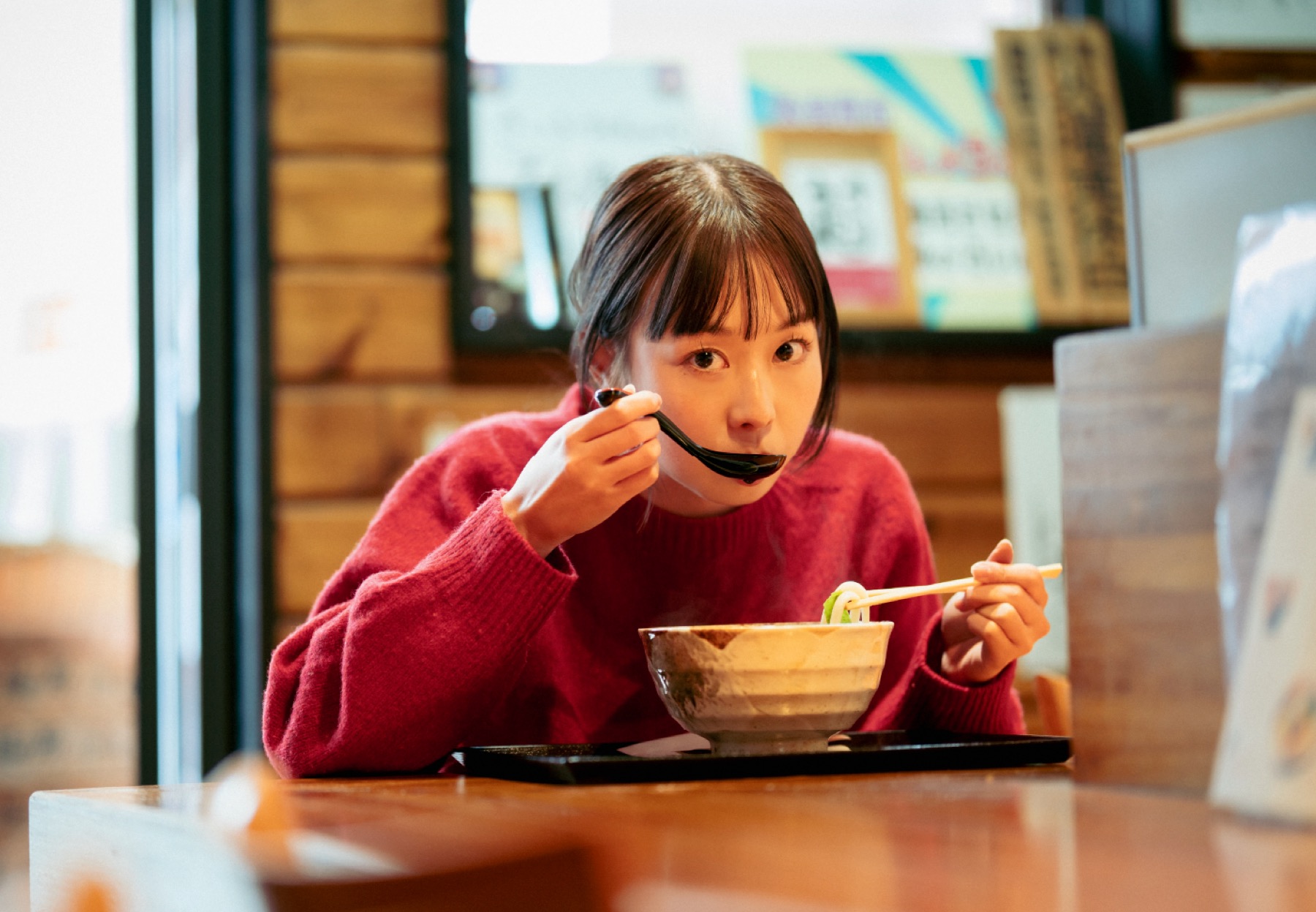 店のカウンターでラーメンを食べる人